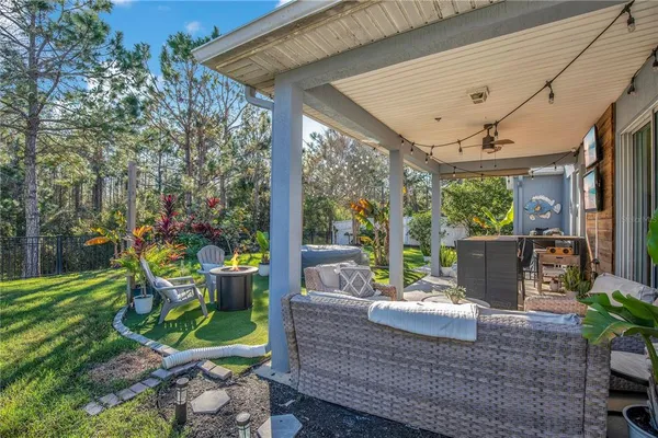 a view of a patio with table and chairs potted plants with wooden floor and floor to ceiling window