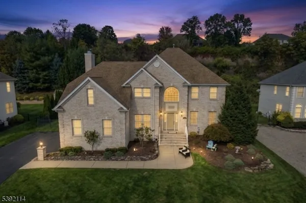 a front view of a house with a yard garden and outdoor seating