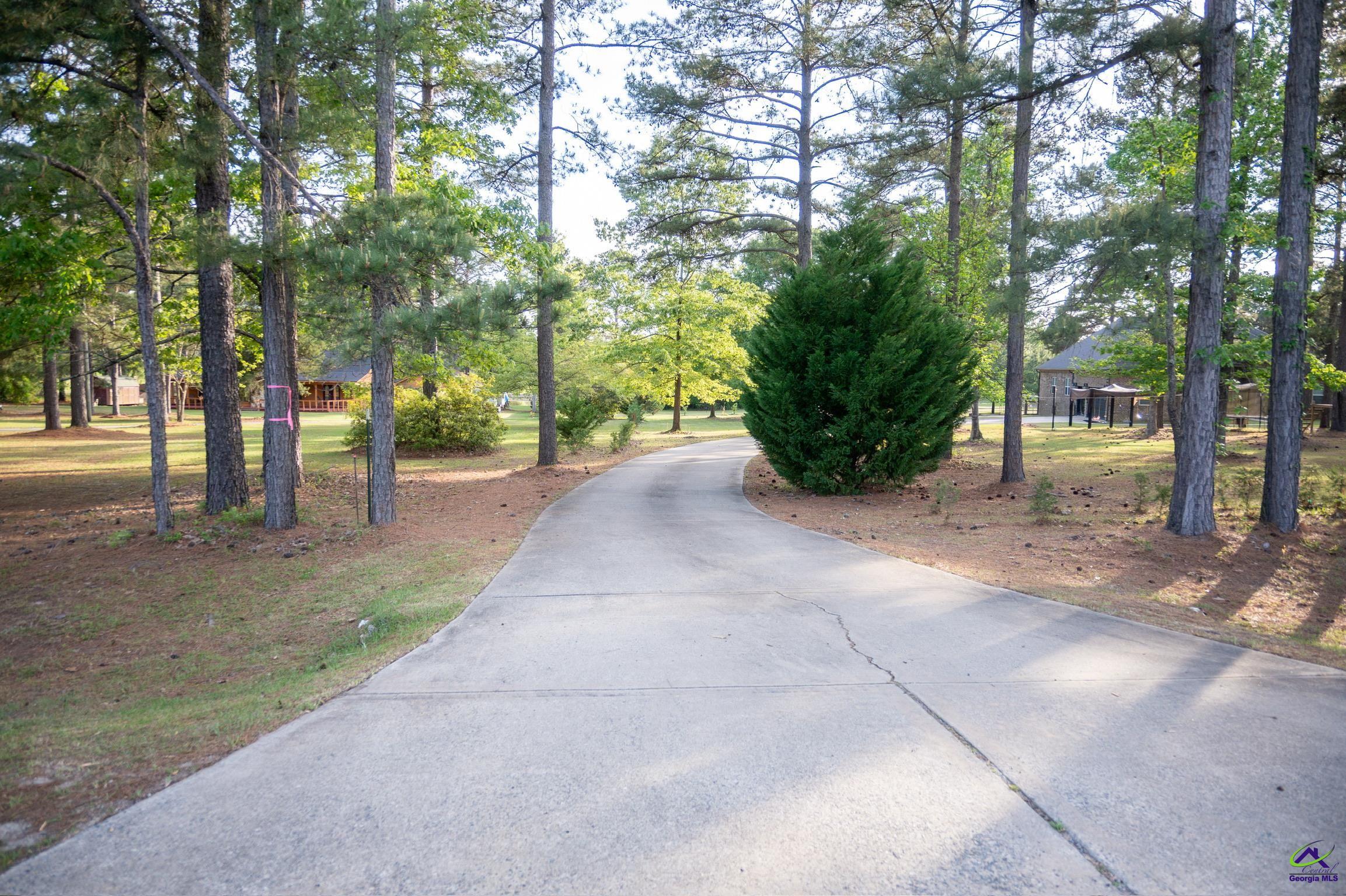 1060 Edna Moore Road Eastman, GA 31023 - Photo 4 of 87 a view of a street with potted plants and large trees