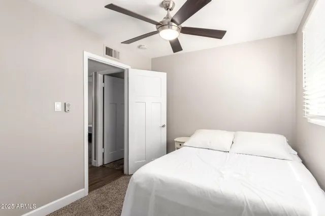 a bedroom with a bed and a ceiling fan