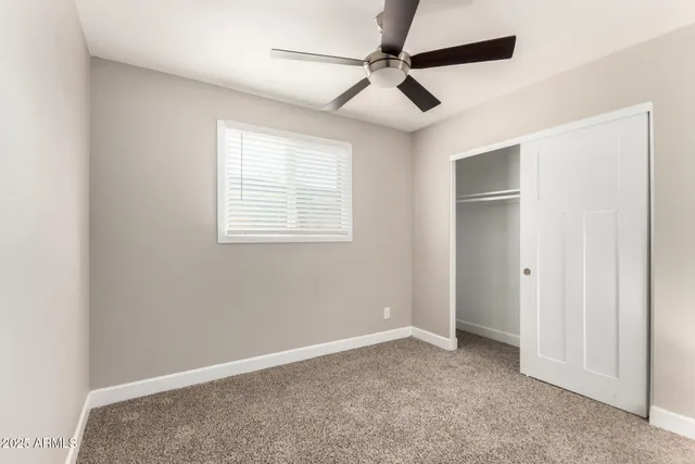 a view of a livingroom with a ceiling fan and window