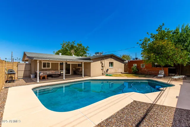 a view of a house with pool and chairs