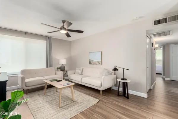 a living room with furniture and a ceiling fan