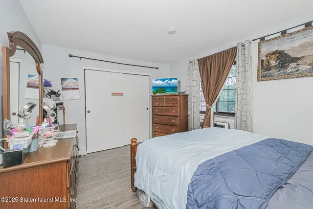 a bedroom with a bed a dresser and book shelf