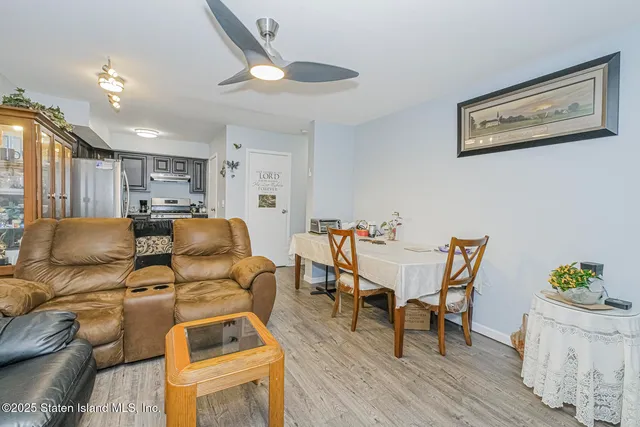 a living room with furniture and a dining table with wooden floor