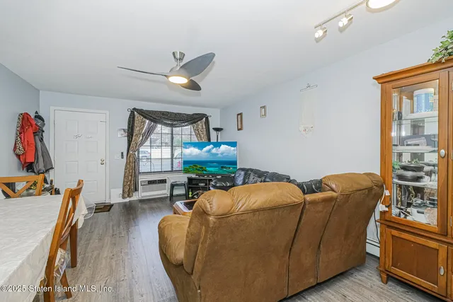 a living room with furniture a wooden floor and a window