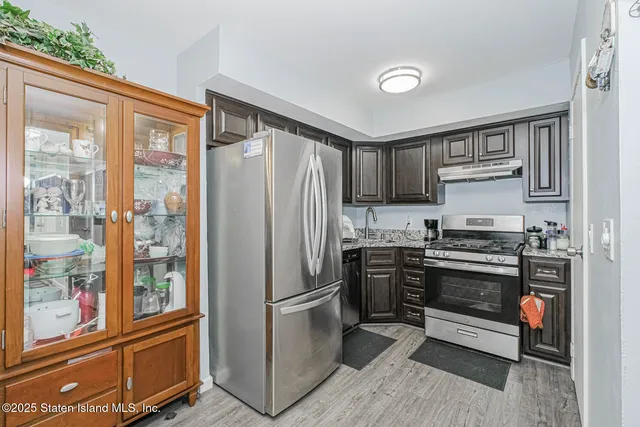 a kitchen with stainless steel appliances granite countertop a refrigerator and a stove top oven