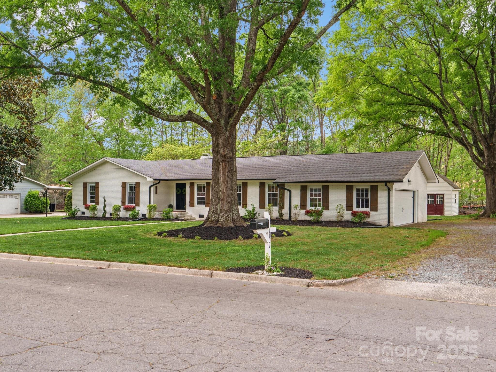 1102 Oak Hill Drive Monroe, NC 28112 - Photo 2 of 33 a front view of a house with a garden and trees