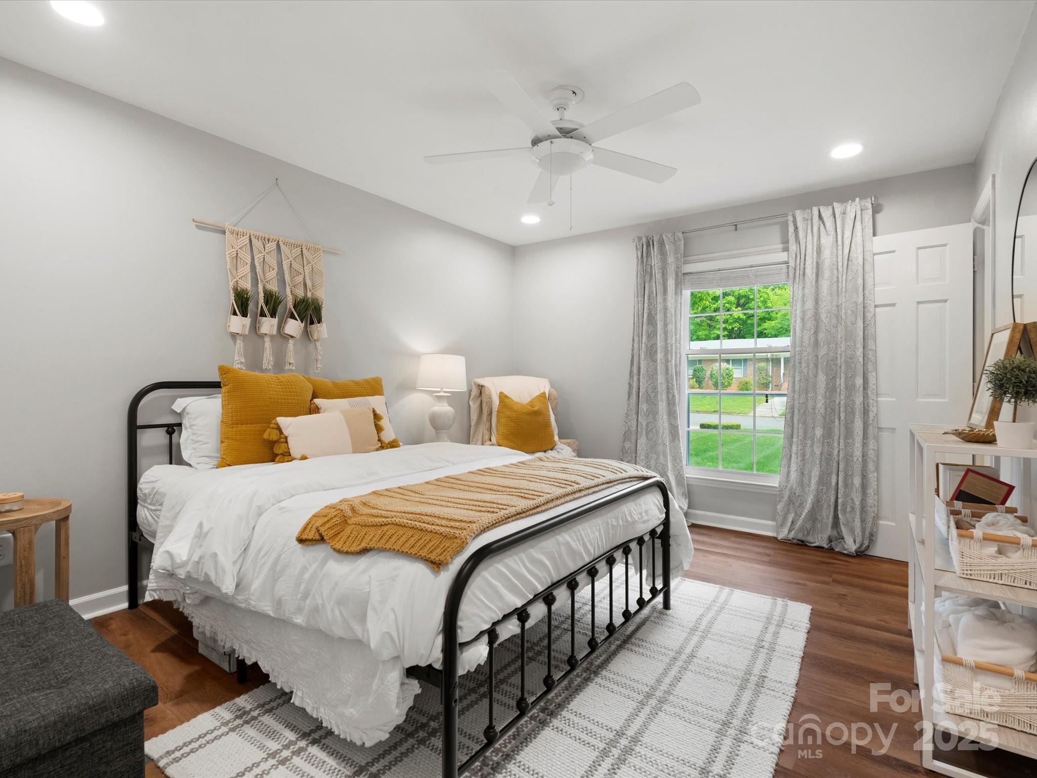 1102 Oak Hill Drive Monroe, NC 28112 - Photo 25 of 33 a bedroom with a bed a chandelier and a flat screen tv