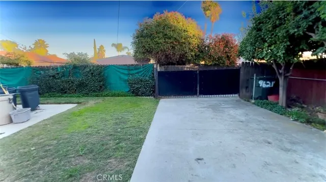 a backyard of a house with plants and tree