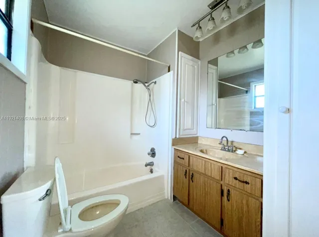 a bathroom with a tub sink toilet and a mirror
