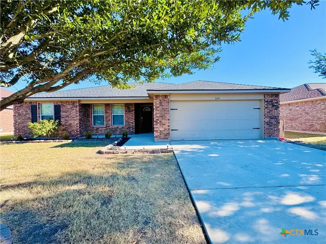 a view of a house with backyard and a tree