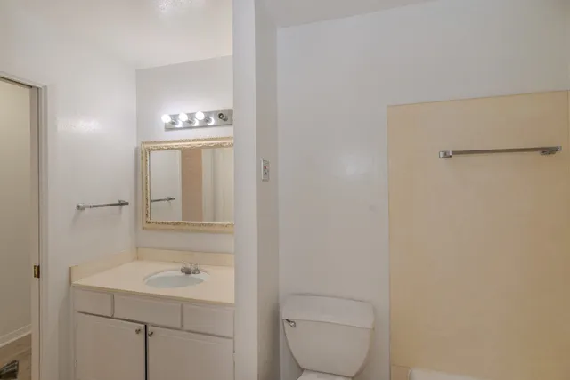 a bathroom with a toilet a sink and mirror