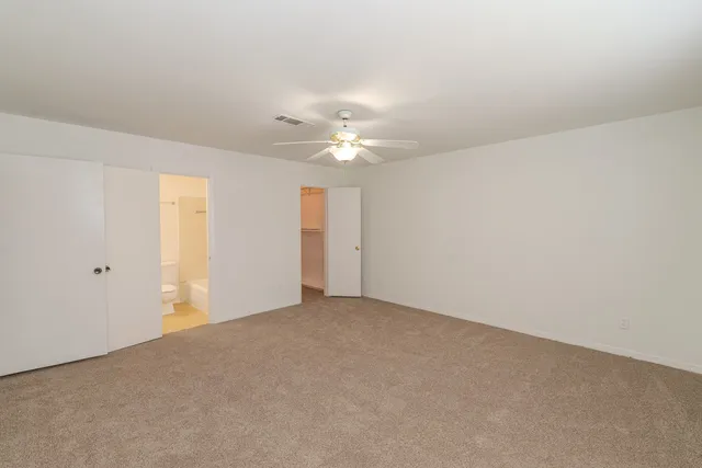 a view of an empty room with a ceiling fan