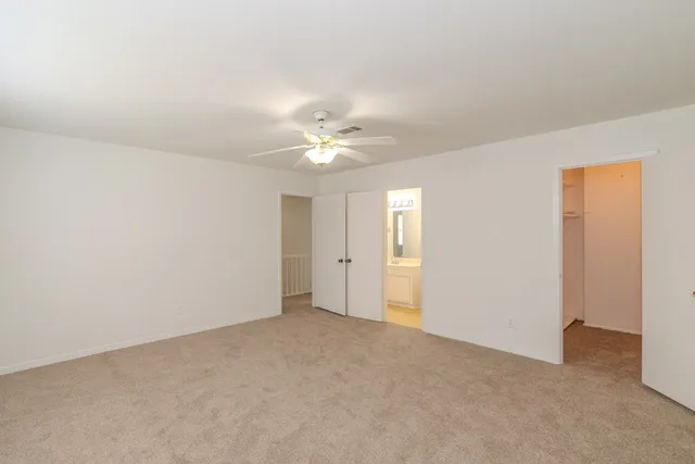a view of an empty room with a ceiling fan