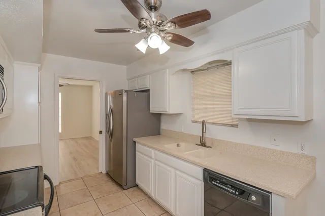 a kitchen with a sink a refrigerator and cabinets