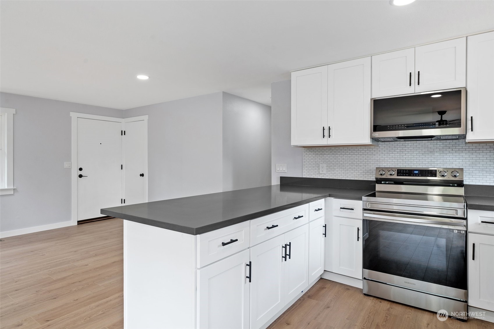 18832 196th Avenue Southeast Renton, WA 98058 - Photo 12 of 33 a kitchen with granite countertop white cabinets and black appliances
