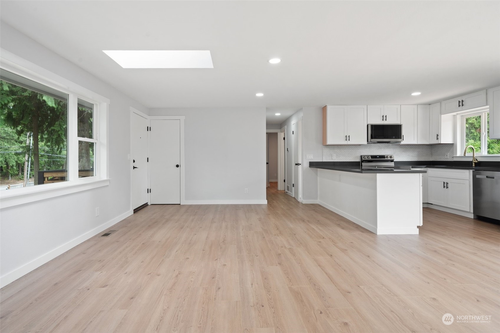 18832 196th Avenue Southeast Renton, WA 98058 - Photo 8 of 33 a kitchen with stainless steel appliances granite countertop a stove top oven a sink and white cabinets with wooden floor