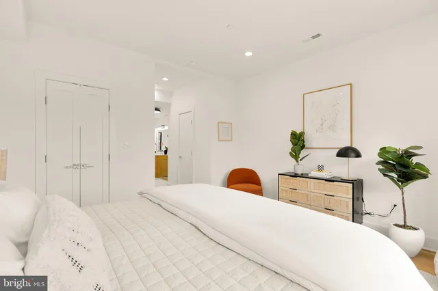 a bedroom with a bed and a potted plant