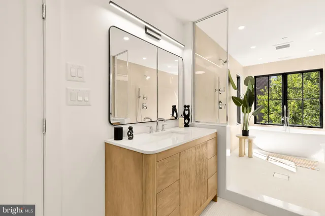 a bathroom with a double vanity sink a mirror and a bathtub