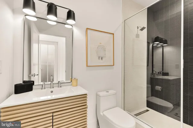 a bathroom with a sink a toilet and shower