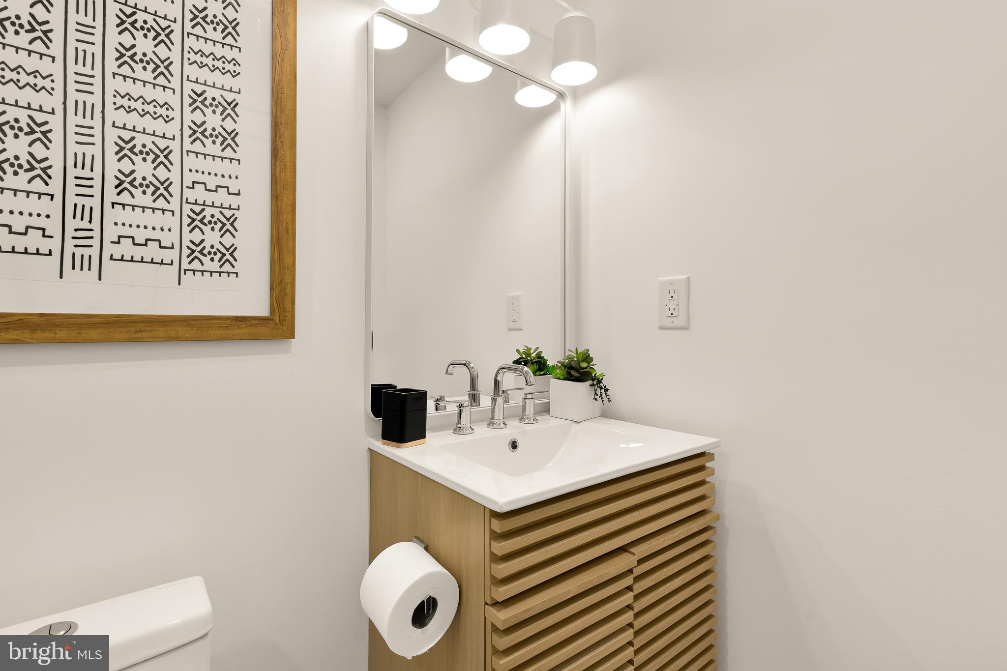 1205 10th Street Northwest, Unit 2 Washington, DC 20001 - Photo 27 of 32 a bathroom with a sink a toilet and a mirror