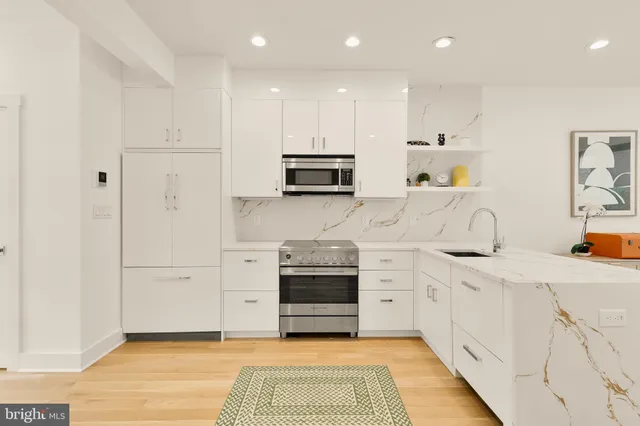 a kitchen with granite countertop a sink and a stove top oven