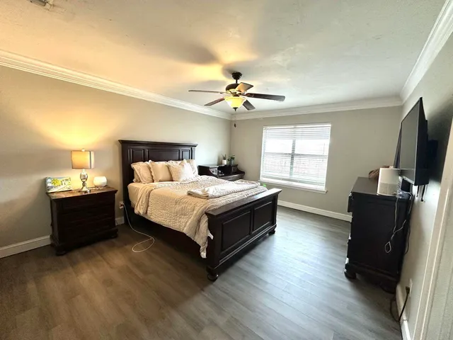a bedroom with a bed and a flat tv screen on a dresser