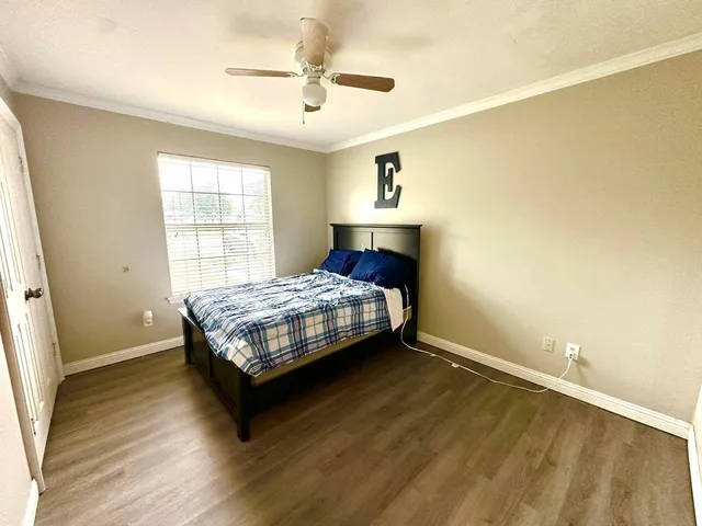 a bedroom with a bed and wooden floor