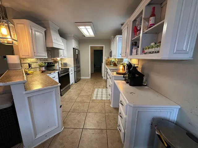 a kitchen with a sink a stove and cabinets