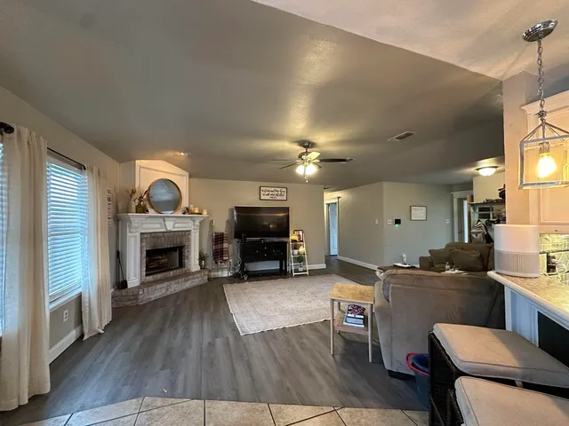 a living room with furniture a fireplace and a flat screen tv