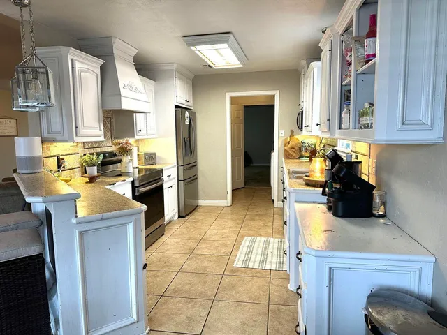 a kitchen with a sink a counter top space cabinets and stainless steel appliances
