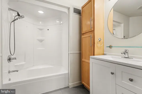a bathroom with a tub sink and mirror