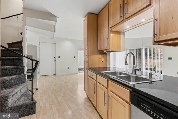 a kitchen with granite countertop a sink and cabinets
