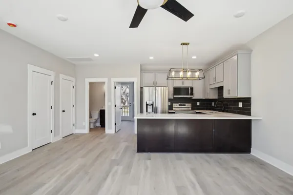 a large kitchen with stainless steel appliances granite countertop a refrigerator and a stove