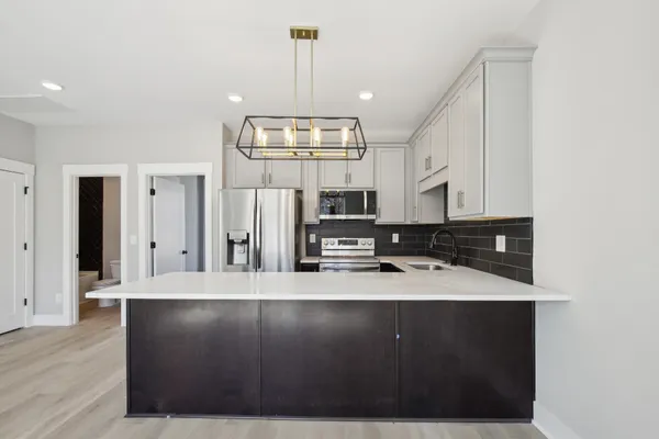 a kitchen with a sink refrigerator and microwave