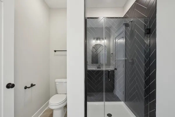 a bathroom with a glass door shower and toilet