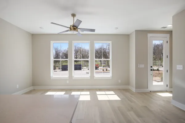 a view of an empty room with a window and wooden floor