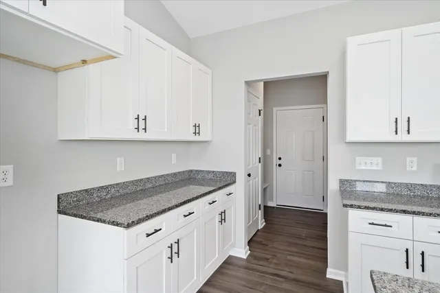 a kitchen with stainless steel appliances granite countertop a sink and dishwasher with white cabinets