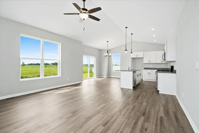 a view of kitchen with stainless steel appliances refrigerator wooden floor and window