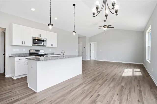 a view of kitchen with sink microwave and cabinets