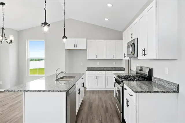 a kitchen with stainless steel appliances granite countertop a sink stove and refrigerator