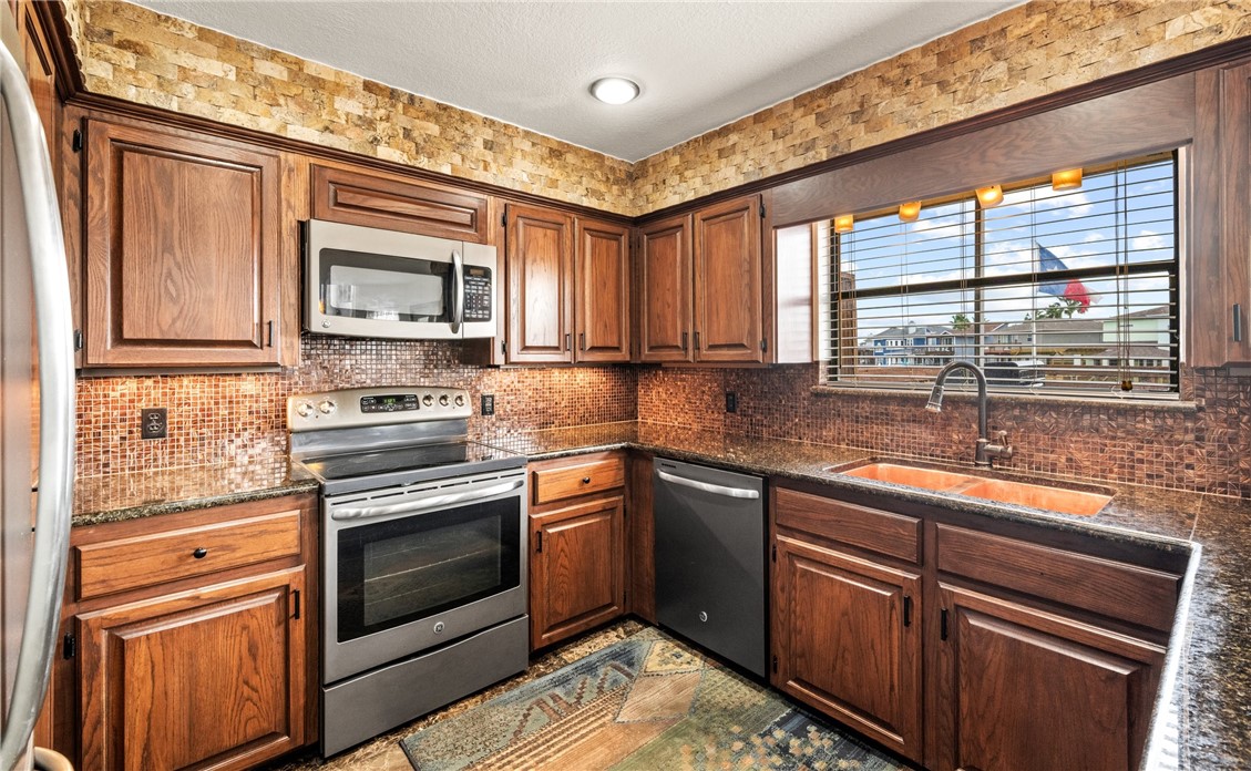 15330 Key Largo Court Corpus Christi, TX 78418 - Photo 9 of 33 a kitchen with stainless steel appliances granite countertop a stove sink and microwave
