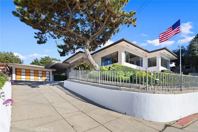 a front view of a house with a garden and plants