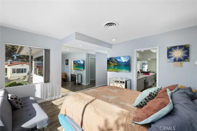 a large bedroom with a bed and wooden floor