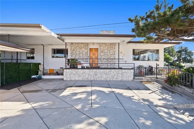 a front view of a house with a garden and plants