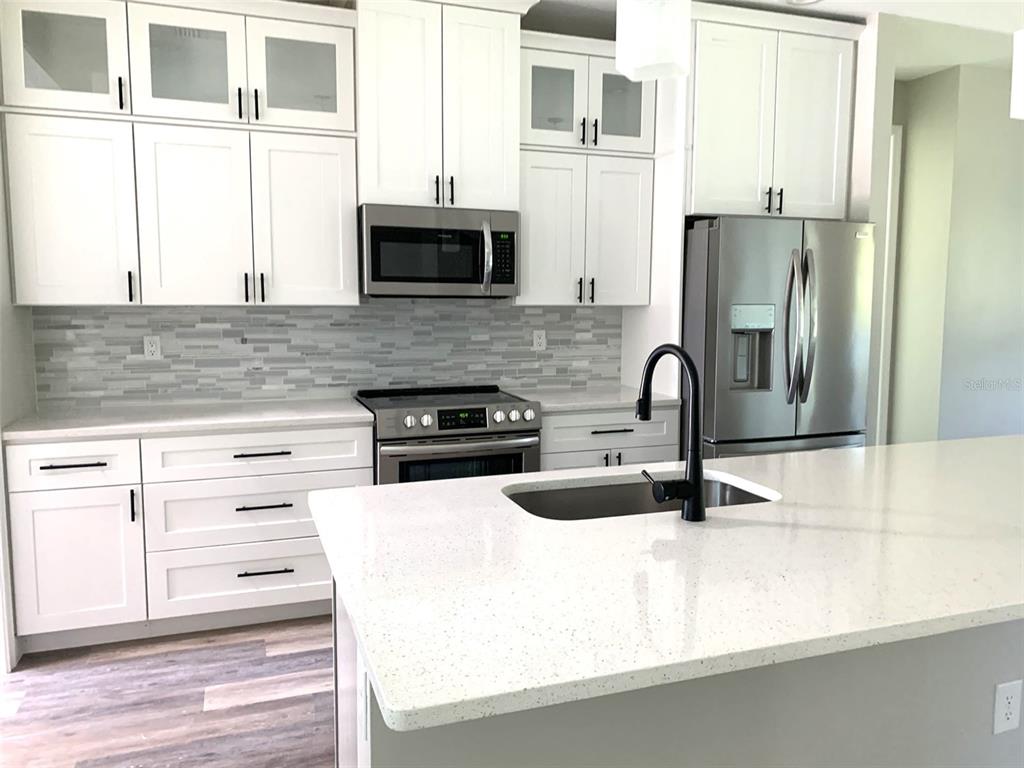 7410 Ellis Lane Port Charlotte, FL 33981 - Photo 3 of 23 a kitchen with stainless steel appliances granite countertop a sink and a stove