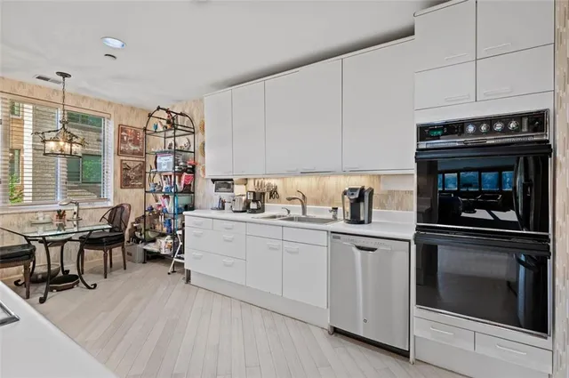 a kitchen with cabinets appliances and a dining table