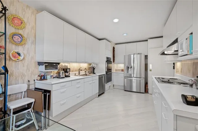 a kitchen with white cabinets and stainless steel appliances