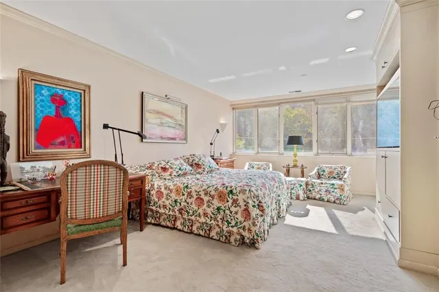 a bedroom with bed and paintings on the wall